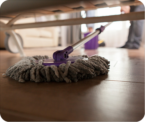 Deep cleaning service with microfiber mop removing dust under furniture for a complete home reset
